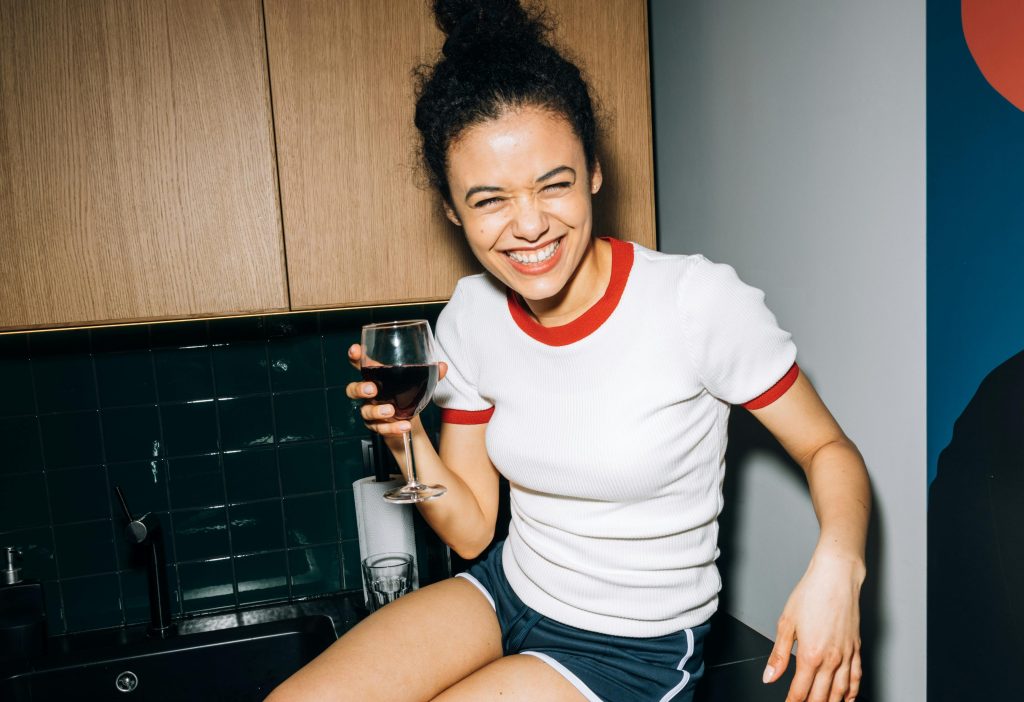 Jeune femme souriante avec un verre de vin.